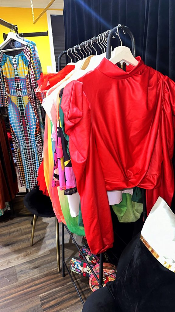 Racks of clothing showing jackets, blouses, and dresses.