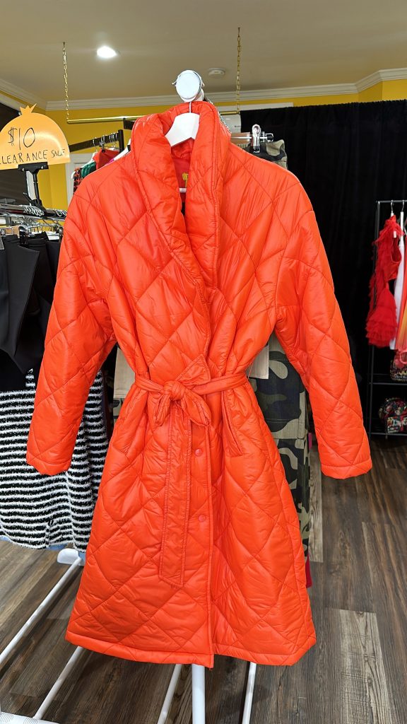 A coat that is bright orange, that is in the puffer quilted style, and it knee length.